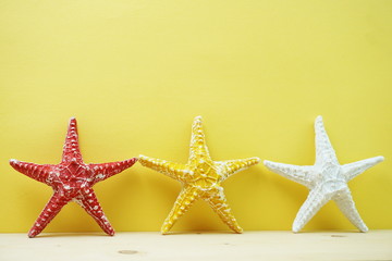 Fototapeta na wymiar summer background starfish figure decoration on yellow background