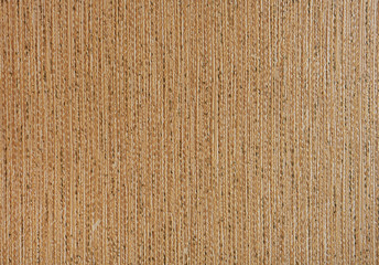 Old beige wallpaper with embossed striped texture.