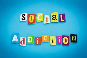 Social addiction. A word writing text of cut letters on a blue background. Headline, card, banner with inscription. Psychological concept.