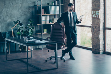 Fototapeta premium Full size photo of handsome successful business guy waiting corporate meeting read e-reader reports wear black blazer shirt tie pants suit standing modern office indoors
