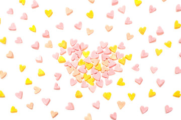 Many multi-colored marshmallows in the shape of hearts are scattered randomly.  Festive background.