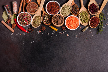 A set of spices and herbs. Indian cuisine. Pepper, salt, paprika, basil and other on a dark...
