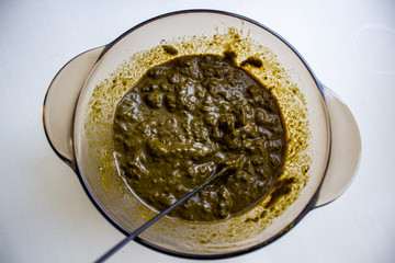 Mixing henna with a wooden spoon in a bowl for hair application of natural color like Indian henna mix.