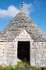 Fototapeta na wymiar Tullo with door, traditional old house and old stone wall in Puglia, Italy, Europe, vertical
