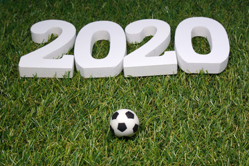 White 2020 with Football on green grass background - Sport 2020 Concept 