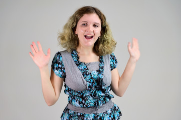 Portrait of a student girl with beautiful magnificent hair. Concept horizontal photo of a young woman with emotions in a turquoise dress stands in front of the camera on a white background.