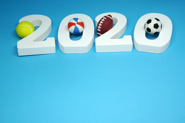 White Wooden 2020 with Football Tennis ball Volleyball Rugby on blue  background - 2020 sport and activity concept - New Challenge and New Goal for the Winner 