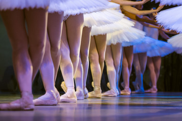 Legs of ballerinas dancing in ballet Swan Lake.