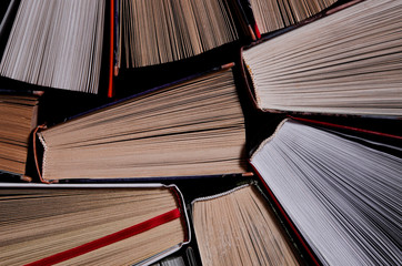 Naklejka premium Books. Lots of colourful thick open books stand on a dark background
