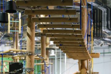 Photography of the fragment of an obstacle course in an amusement park for children. Wooden staircase. Concepts of sports leisure activity and healthy lifestyles.