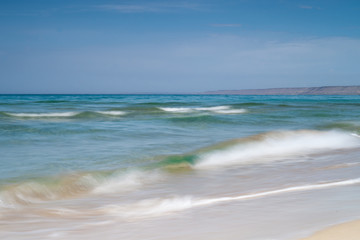 View of blue sea waves at sandy beach. Horizon line. Caspian Sea, sandstone coast. ustyurt. Selective focus, long shutter speed