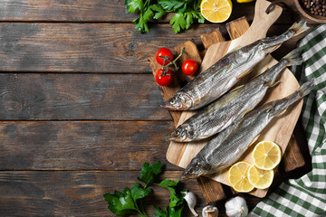 Smoked or dried smelt fish on a wooden Board on a brown wooden table. Top view with space for text
