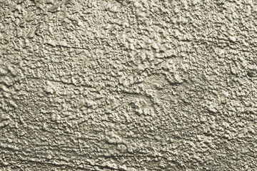 Natural pattern of painted wall. Green and gray concrete surface. Textured background of urban exterior, stucco. Abstract shiny architecture backdrop, uneven facade of building.