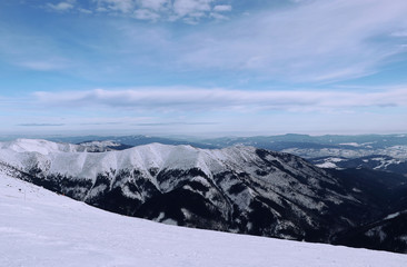 View on Vajskovska and Jasenianska valley from Chopok mountain in Low Tatras, Slovakia. Fairy-tale landscape with many snowy hills and sky with many shadows of blue. Paradise same as in Alps