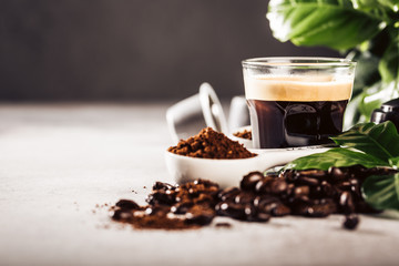 Background with glass cup of coffee, coffee beans and leafs. Beverage cafe shop concept with copy...