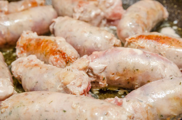 Sausages for grilling fried in a pan close-up