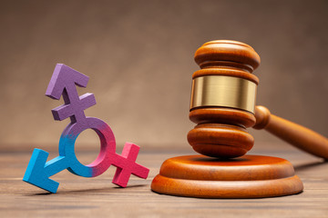 Transgender symbol and judge gavel on brown background. Concept of prohibition or permission for...