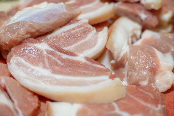 Medium-sized chunks of fresh raw pork red meat on a kitchen plank close-up. Preparation of barbecue, roast, meat dishes, food, pork. Background texture.