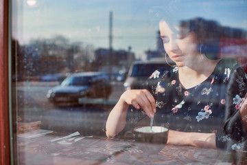 Obraz premium Cafe city lifestyle woman on phone drinking coffee texting text message on smartphone app sitting indoor in trendy urban cafe.
