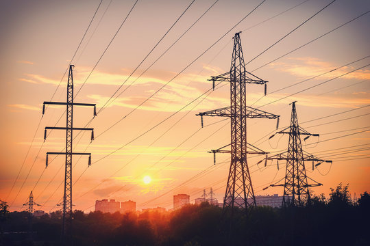 Power Lines On The Background Of The City In The Light Of Sunset