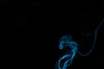 Obraz premium Beautiful abstract blue smoke with copy space on black background. Smoke background for art design or drawing. Abstract figure of the smoke