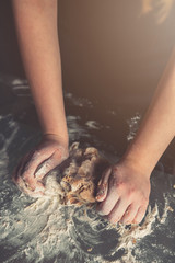 girl preparing cookies in the shape of a heart for the holiday Valentine's Day at home, in a small bakery, family business, authentic, hobby, mood, cozy. Care and love