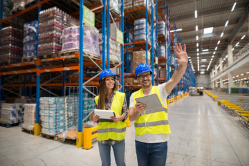 Warehouse workers checking organization and distribution of products in large storage area....