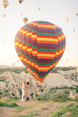 Wedding travel. Honeymoon trip. Couple in love among balloons. Couple in love in Cappadocia. Couple in Turkey. Man and woman traveling. Flying on balloons