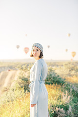 Fototapeta na wymiar Beautiful woman watching colorful hot air balloons flying over the valley at Cappadocia, Turkey Cappadocia fairytale scenery of mountains