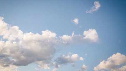 Beautiful white soft fluffy clouds on a pale blue sky background, 16:9 panoramic format