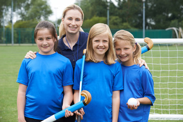 Portrait Of Girls Hockey Team With Female Coach At School