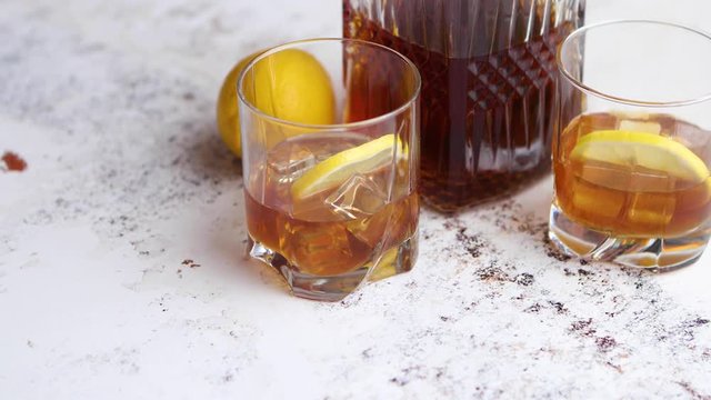 Whiskey sour drink with lemon in glass on stone rustical background