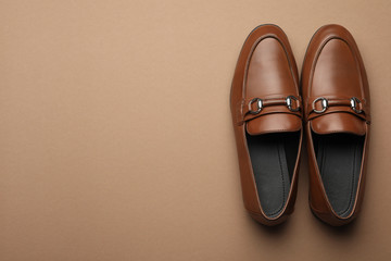 Pair of stylish male shoes on brown background, top view. Space for text