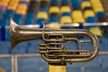 Vintage copper trumpet in front of a colorful background