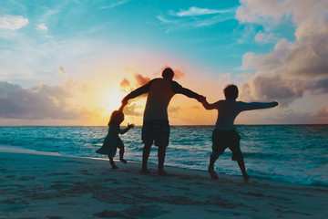 Fototapeta premium father with two kids play on beach at sunset