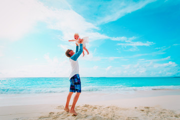 father and cute little daughter play at beach