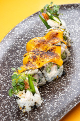 Sushi roll with crab under melted cheese. Sushi trend. Creative food.