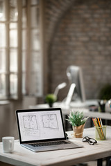 Housing plans on computer monitor on a desk in the office.