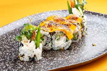 Sushi roll with crab under melted cheese. Sushi trend. Creative food.