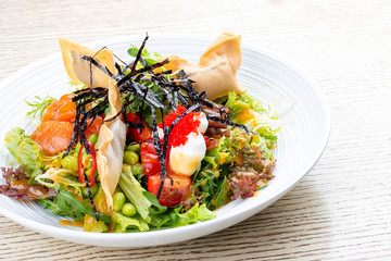 Salmon salad with cream cheese, pickled pumpkin, daikon, beans, tobiko caviar and mango chili sauce. Pan-Asian dish.