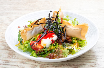 Salmon salad with cream cheese, pickled pumpkin, daikon, beans, tobiko caviar and mango chili sauce. Pan-Asian dish.