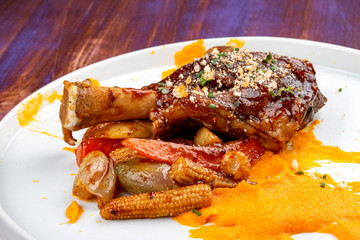 Lamb shank with demiglas sauce, carrot puree with caramelized vegetables