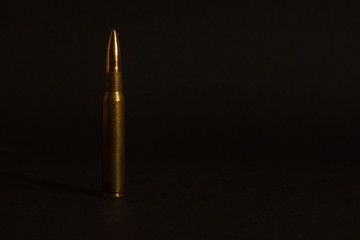 Cartridge for a rifle on a dark background. Copy space