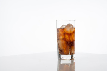 Cold refreshing cola glass with ice on white background with space for text. Icy beverage of cool drink with caffeine