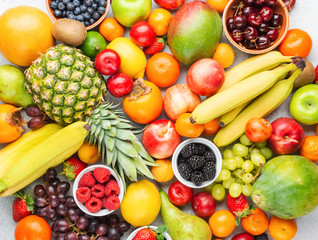 Healthy fruits vegetables background filled with strawberries raspberries oranges plums apples kiwis grapes broccoli cauiliflower mango persimmon pineapple
