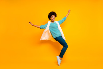 Fototapeta na wymiar Full body photo of cheerful funny crazy afro american girl enjoy dance autumn holiday emotions raise hands wear white blue fluffy waistcoat pants shine isolated bright color background
