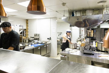 Chef in the kitchen at the restaurant prepares dishes