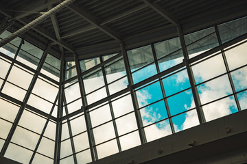 factory hall inside view of modern industrial architecture white and gray walls and pipes with window frame with cloudy sky background view