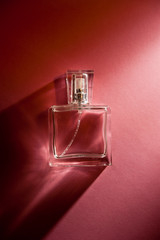 cosmetics - a bottle of perfume over pink background with copy space in romantic style 