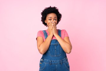 African american woman with overalls over isolated pink background with surprise facial expression